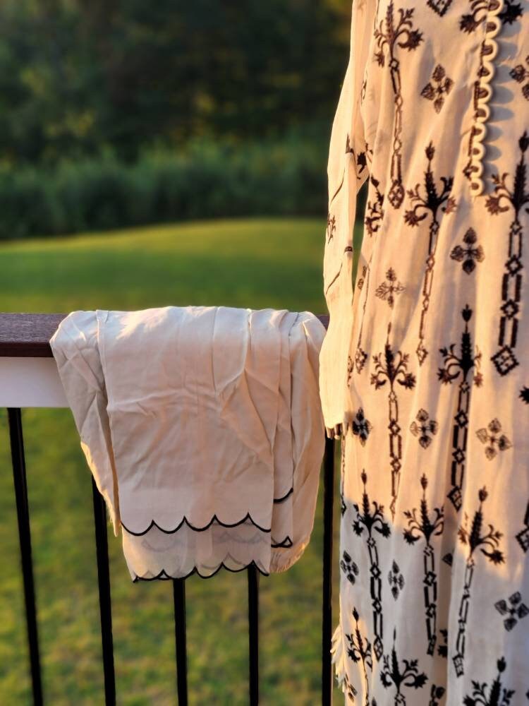 Beige/black  khadi net with all over cross stitch and satin stitch work.Paired with matching raw silk trousers to exude sheer elegance.